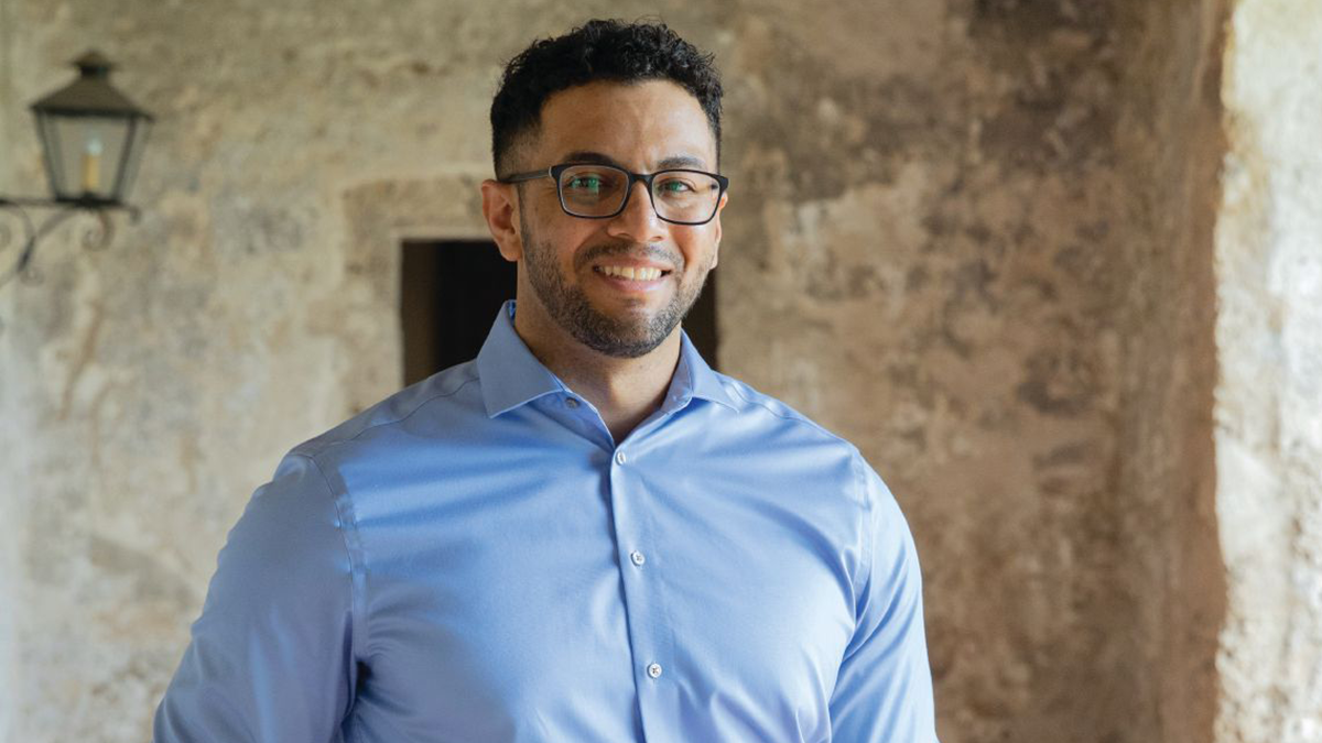 Dr. Joshua Hernandez standing and smiling